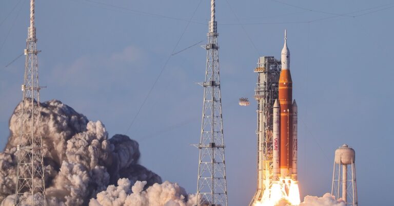 El cohete SLS de la NASA despegando en la misión Artemis II desde Florida, con una estela de fuego y humo.