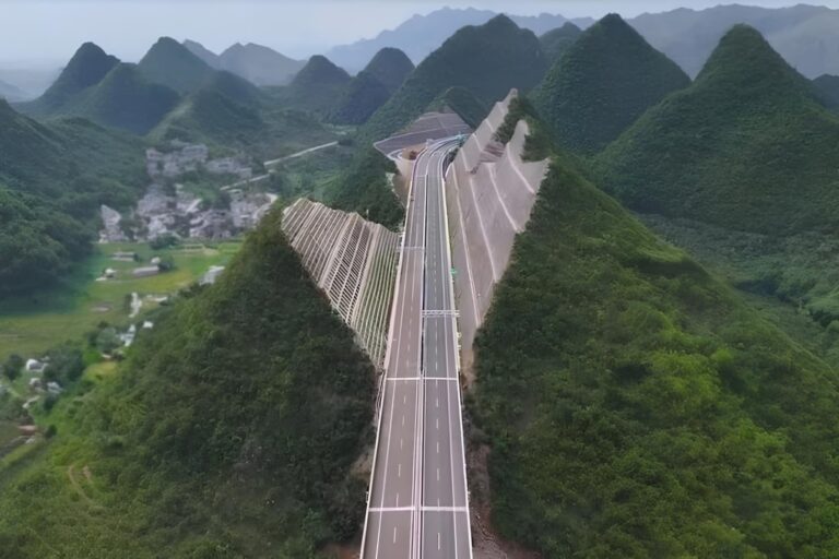 Vista aérea de la autopista cortada entre dos paredones de montaña en Guizhou, China