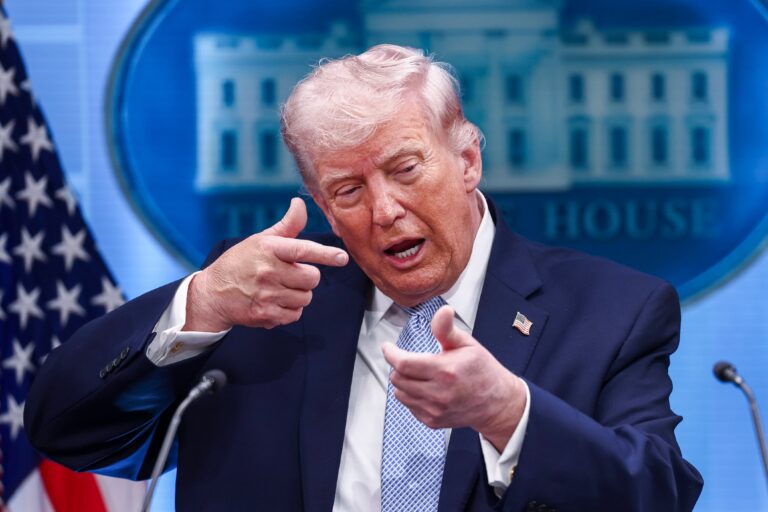 Donald Trump durante una conferencia de prensa, con la bandera de Estados Unidos de fondo.