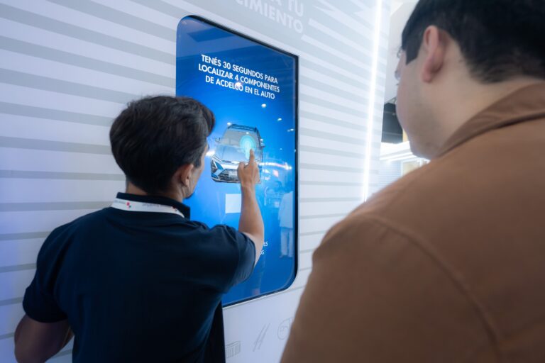 Stand de General Motors en la feria Automechanika Buenos Aires, mostrando pantallas digitales y repuestos.