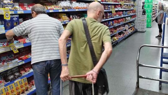 Persona pagando con el celular en la caja de un supermercado, promociones MODO