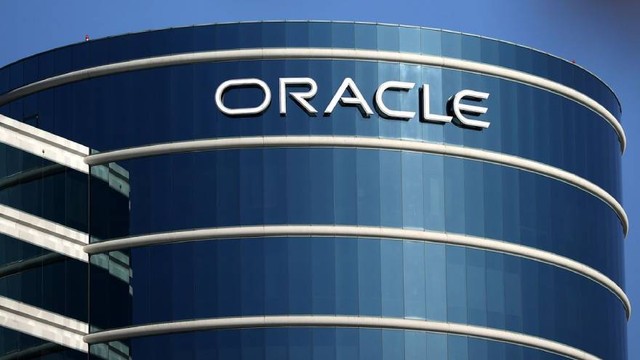 Logotipo de Oracle en una pantalla con gráficos de tendencia financiera de fondo