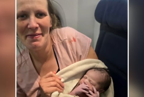 Interior de un avión de Delta Air Lines con tripulación atendiendo a una pasajera embarazada