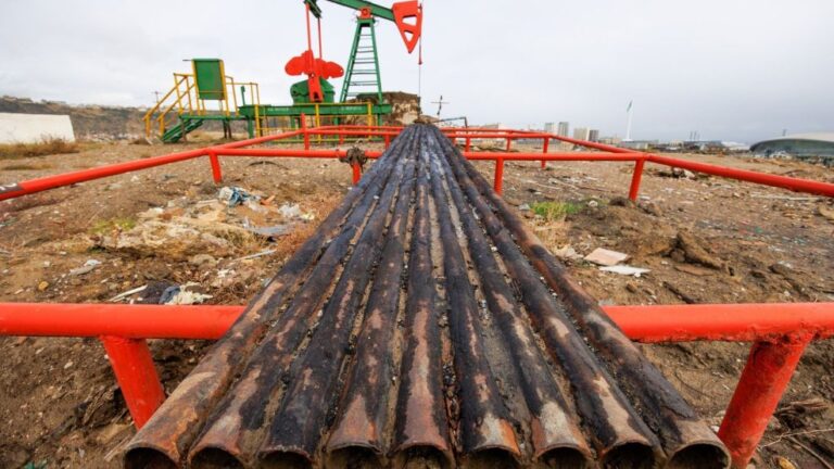 Barriles de petróleo y gráfico de precios en alza, con referencia al estrecho de Ormuz