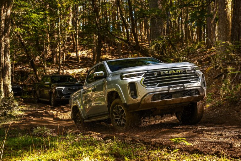 Pickup RAM Dakota color gris en camino de tierra, vista lateral mostrando su diseño.