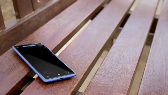 Persona sosteniendo un celular con un símbolo de escudo de seguridad superpuesto