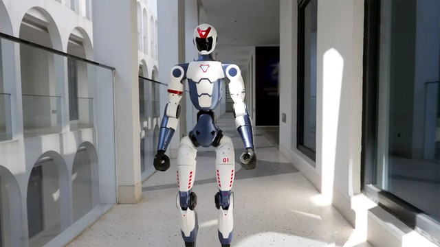 Robot humanoide Unitree R1 de color plateado realizando una postura dinámica sobre una superficie clara.