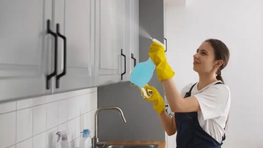 Trabajadora doméstica realizando tareas de limpieza en una vivienda