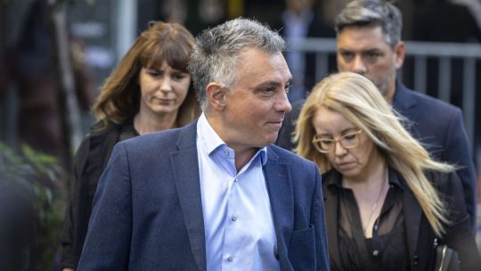 Ilustración de un teléfono móvil mostrando redes sociales con logos de Twitter y streams, sobre un fondo que representa tensión política.