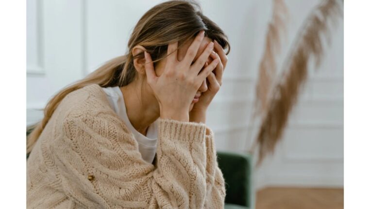 Mujer sentada en posición de meditación con expresión tranquila, ilustrando técnicas para controlar la ansiedad