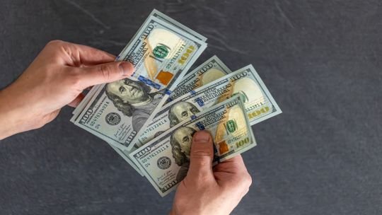 Billetes de dólar y pesos argentinos sobre una mesa