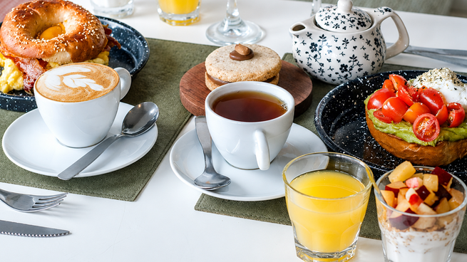 Tetera y taza de té sobre una mesa con pastelería artesanal