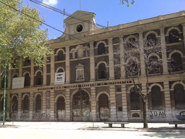 Fachada del histórico edificio de Alpargatas en Barracas, con ladrillos a la vista y ventanas de medio punto