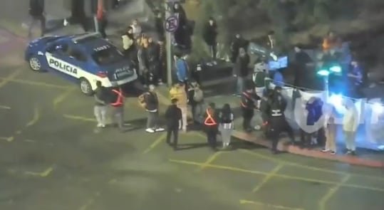 Efectivo policial tendido en el suelo tras ser atacado con botellas durante festejos en Córdoba