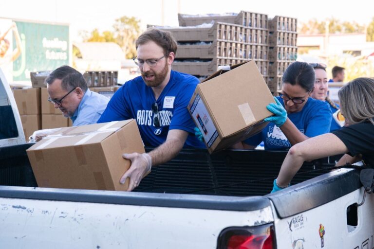 Personas recibiendo bolsas de comida en una distribución gratuita en Florida