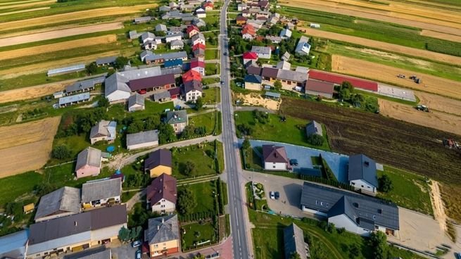 Vista aérea de la calle principal de Suloszowa, Polonia, con campos agrícolas a ambos lados