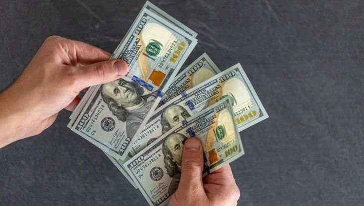 Sobres de papel con dinero en efectivo y monedas sobre una mesa