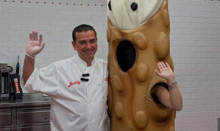 Buddy Valastro sosteniendo una torta decorada en su panadería