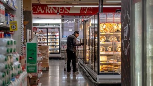 Góndola de supermercado con productos alimenticios y etiquetas de precios
