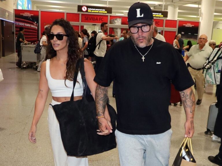 Kiko Rivera en el aeropuerto de Sevilla caminando con dificultad apoyado en su novia