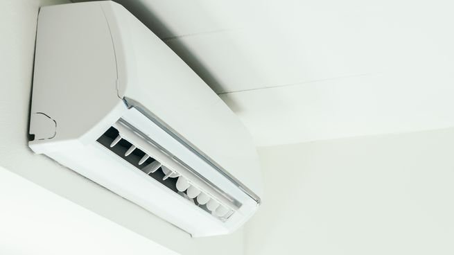 Persona ajustando termostato de aire acondicionado en invierno