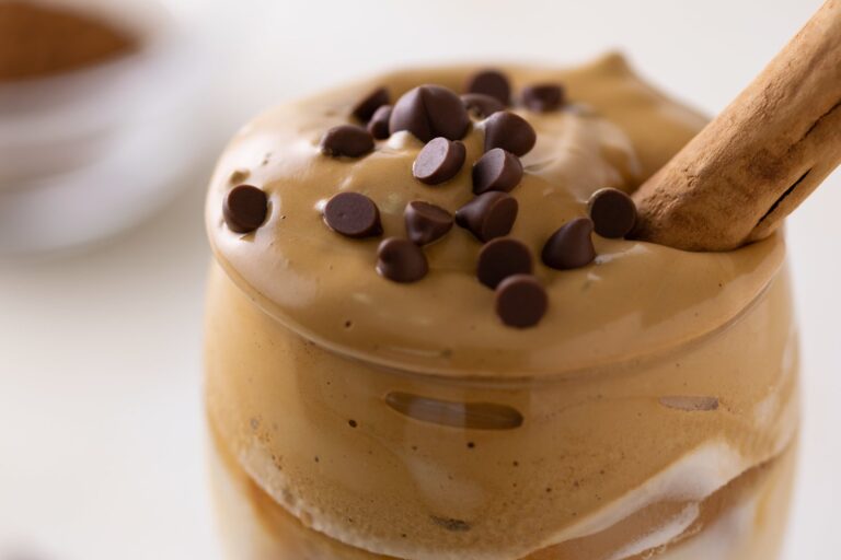 Crema de café con yogur griego en vaso decorada con cacao en polvo y frutas