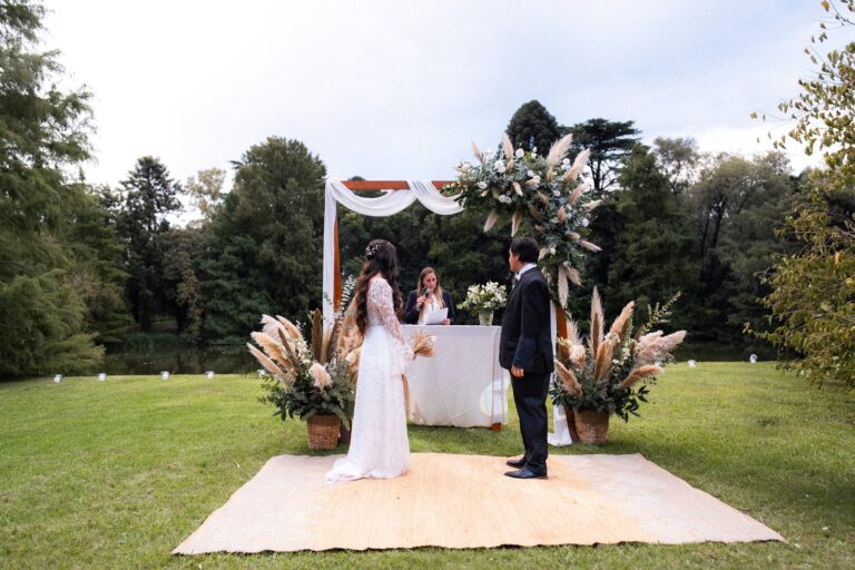 Pareja de novios en una ceremonia al aire libre frente a un lago