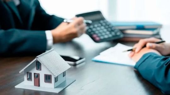 Fachada de un banco con cartel de créditos hipotecarios