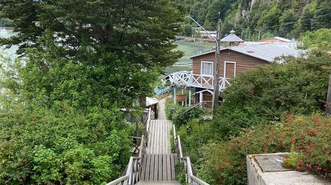 Vista de las pasarelas de madera de Caleta Tortel, en la Patagonia chilena, con viviendas sobre la ladera y el fiordo