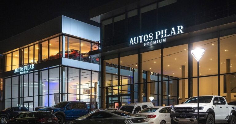 Fachada de la concesionaria Autos Pilar Premium con ventanales cubiertos