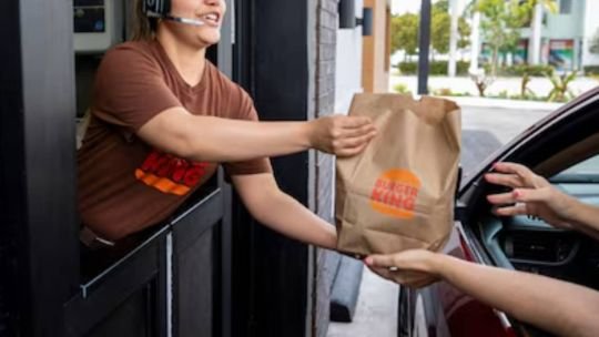 Empleados de servicios rápidos en mostrador de local de comida