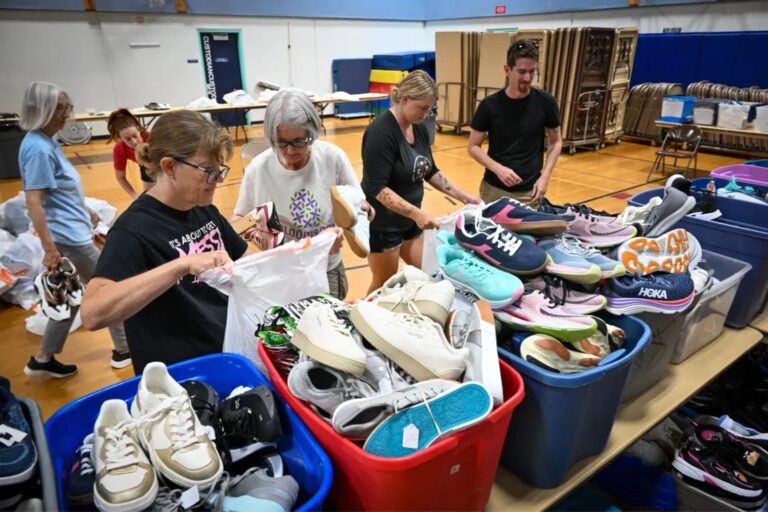 Maggie Driscoll, estudiante de 15 años, junto a cajas con zapatos recolectados para donar