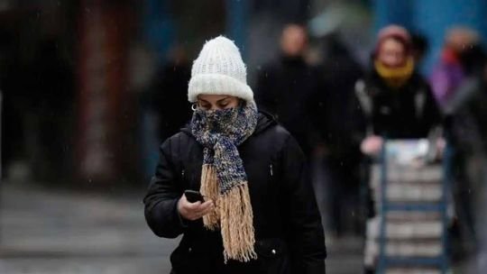 Personas abrigadas caminando por una calle de Buenos Aires durante la ola de frío