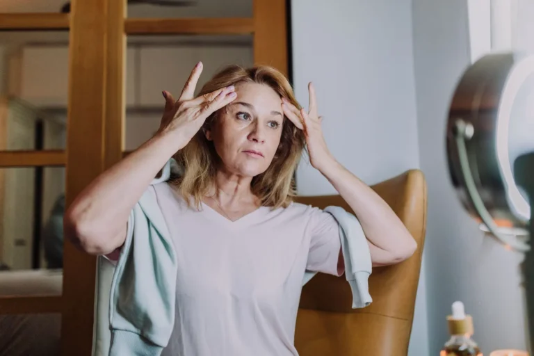 Mujer aplicándose protector solar en el rostro