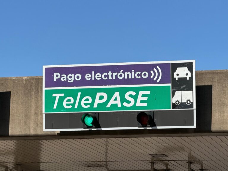 Cabina de peaje con señalización violeta para pago electrónico en autopista de Buenos Aires